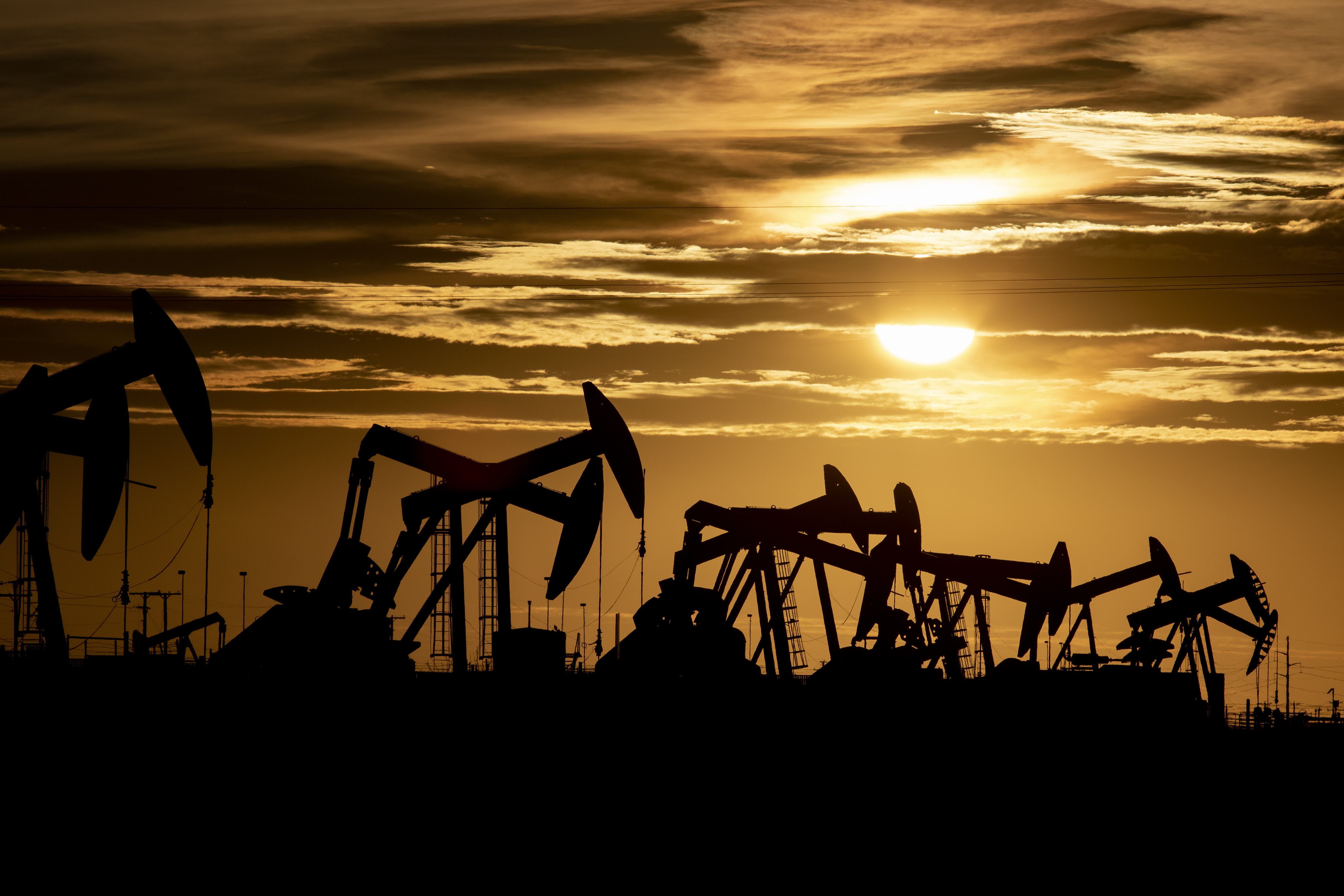Silhouette of oil pumps at sunset.