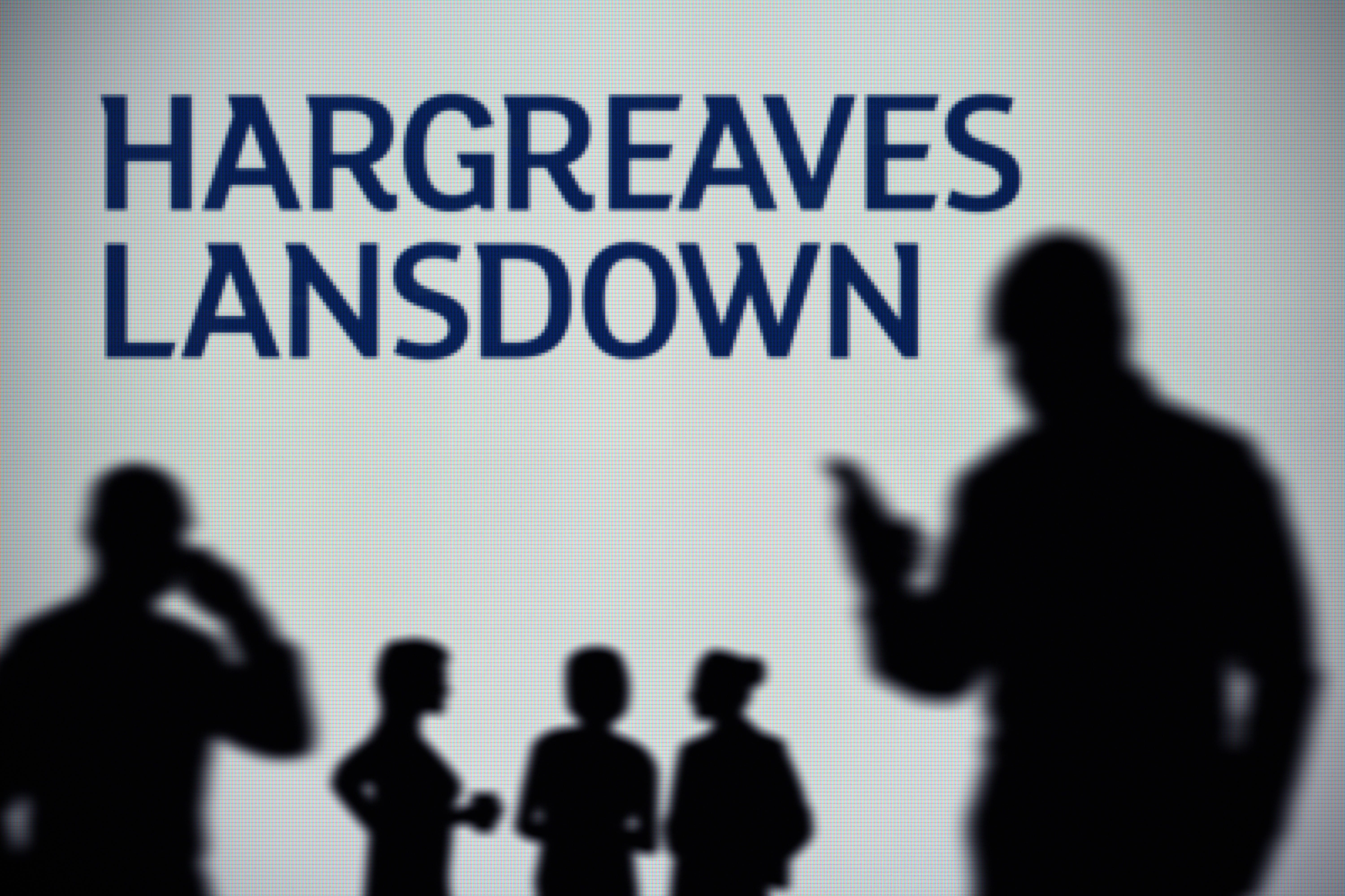 Silhouetted figures in front of a screen displaying the Hargreaves Lansdown logo.